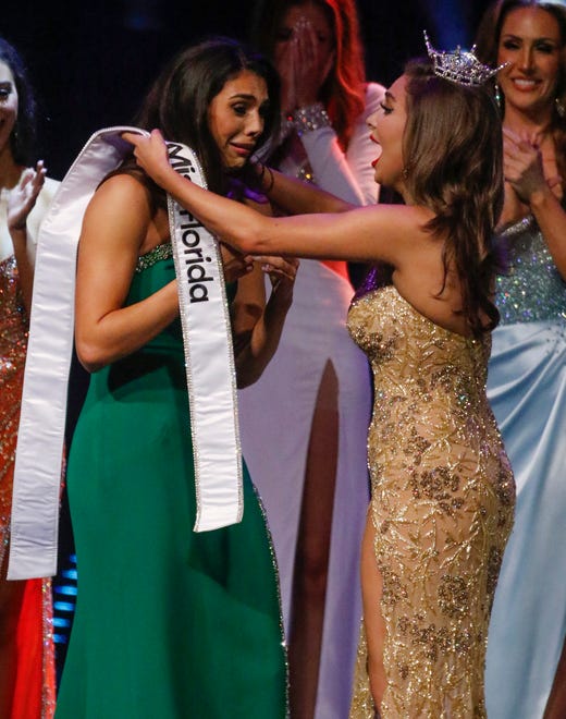 Miss Tampa Casana Fink reacts as Miss Florida 2023 Juliette Valle pins the 2024 Miss Florida sash on her after winning the title at the 2024 Miss Florida Pageant Finals at the RP Funding Center in Lakeland on Saturday June 29, 2024.