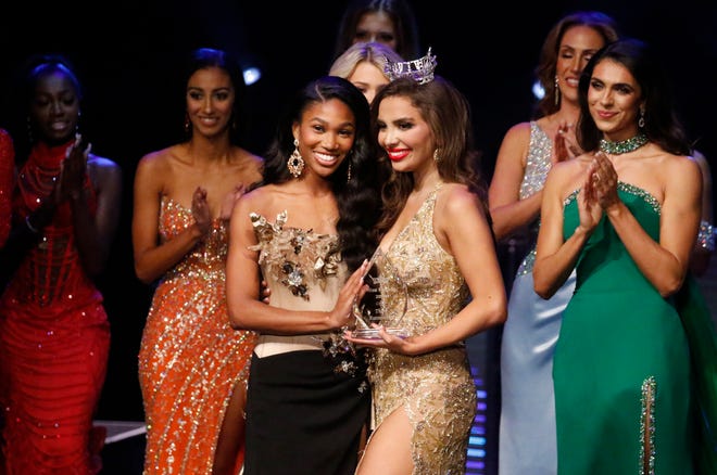 Miss Northeast Florida Paris Richardson receives the third runner-up scholarship trophy form the Miss Florida 2023 Juliette Valle as the final names are called at the 2024 Miss Florida Pageant Finals at the RP Funding Center in Lakeland on Saturday June 29, 2024.