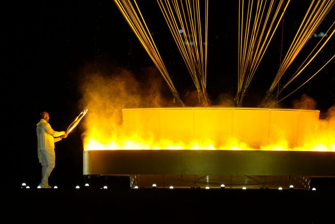 Teddy Riner and Marie-Jose Perec light the cauldron during the opening ceremony for the Paris 2024 Olympic Summer Games.