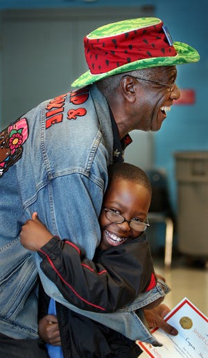 Wally Amos--the founder of Famous Amos cookies, got a hug from Pineview Elementary School third grader Eugene Moore during presentation of Amos' "Smart Cookie" awards presented to children for reading excellence. Amos has been a tireless advocate for literacy and he made a special visit to Tallahassee in 2006.
